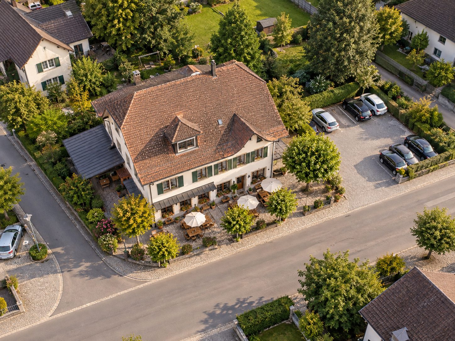 Luftaufnahme des Restaurant Löwen von oben, mit Gastgarten, Parkplatz und der Strasse davor